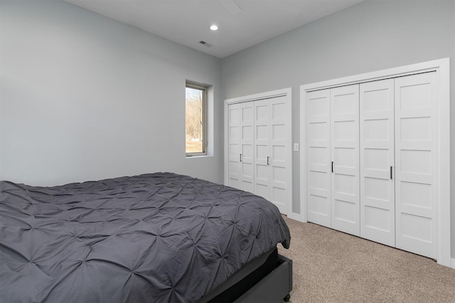 bedroom featuring carpet, two closets, visible vents, and recessed lighting