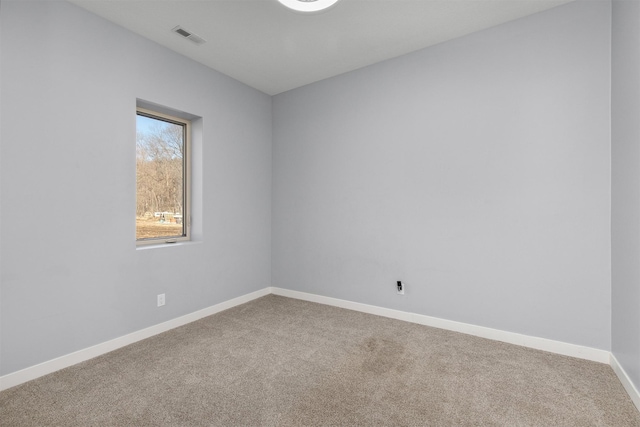 carpeted spare room featuring visible vents and baseboards