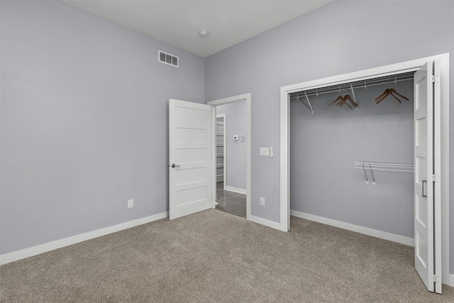 unfurnished bedroom featuring carpet floors, baseboards, visible vents, and a closet