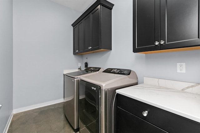 laundry area featuring independent washer and dryer, cabinet space, and baseboards