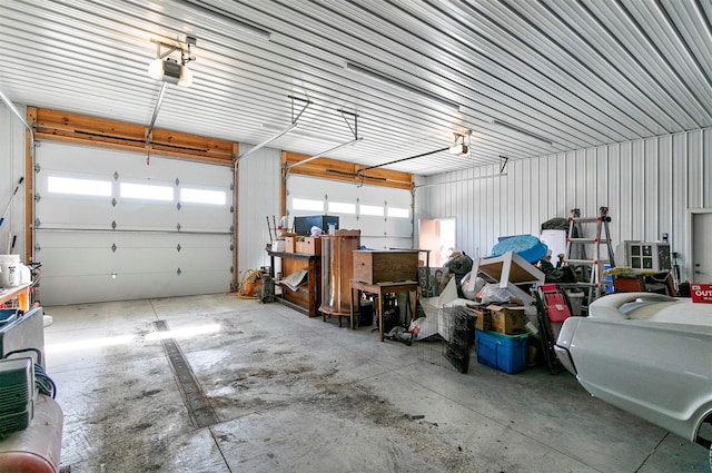 garage featuring a garage door opener and metal wall