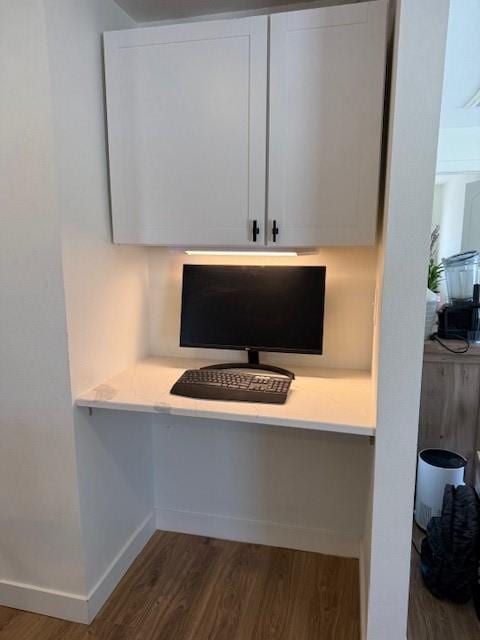 room details featuring built in desk, baseboards, and wood finished floors