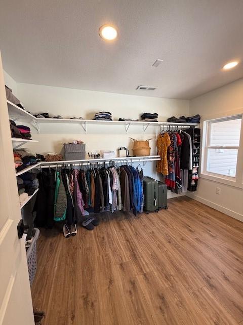 walk in closet with visible vents and wood finished floors