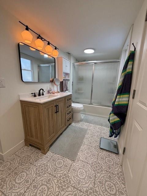 full bathroom featuring enclosed tub / shower combo, toilet, vanity, baseboards, and tile patterned floors