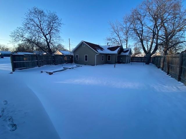 yard covered in snow with a fenced backyard