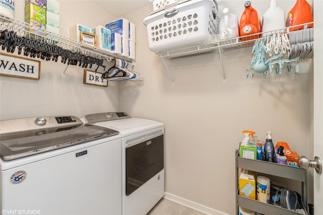 clothes washing area with laundry area, washing machine and dryer, and baseboards