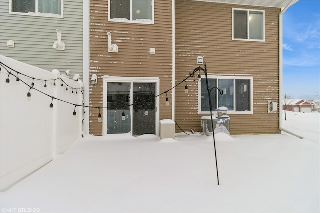 snow covered house featuring a patio area