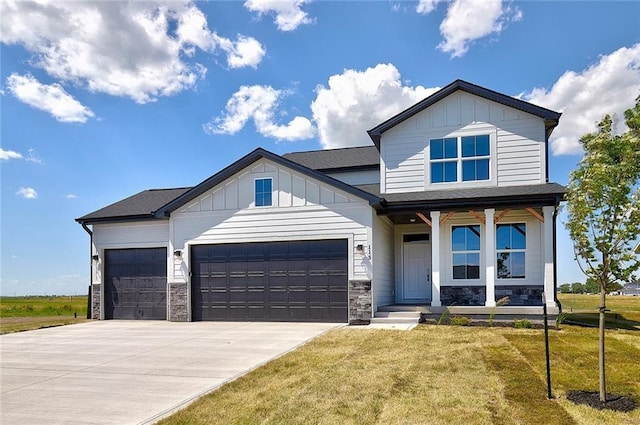 view of front of property with a garage, driveway, a front lawn, and board and batten siding