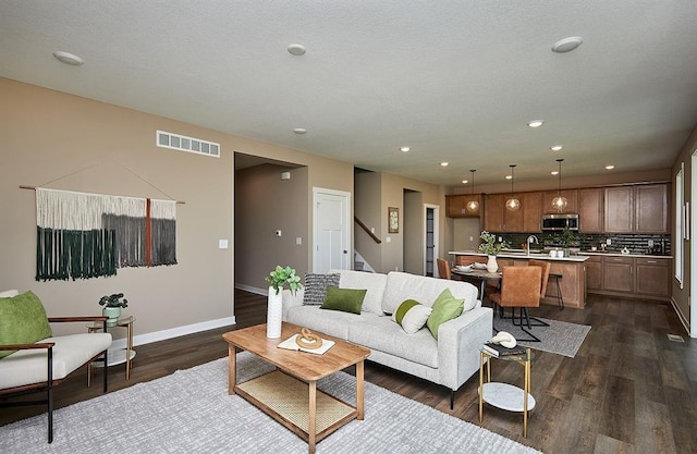 living room featuring recessed lighting, visible vents, baseboards, stairway, and dark wood-style floors