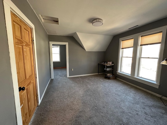 additional living space with vaulted ceiling, carpet, attic access, and baseboards