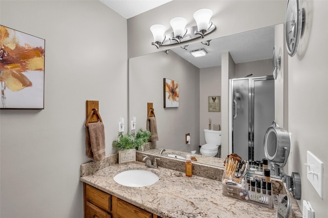 full bath featuring a stall shower, vanity, and toilet