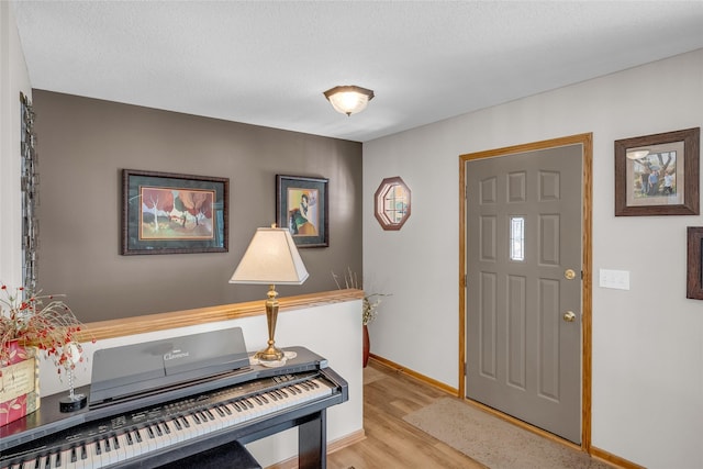 entryway featuring baseboards and light wood-style floors