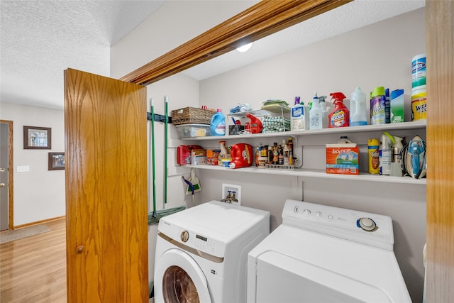 washroom with laundry area, independent washer and dryer, a textured ceiling, and wood finished floors