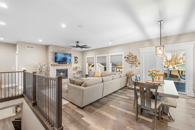 living area with light wood finished floors, a fireplace, visible vents, and recessed lighting