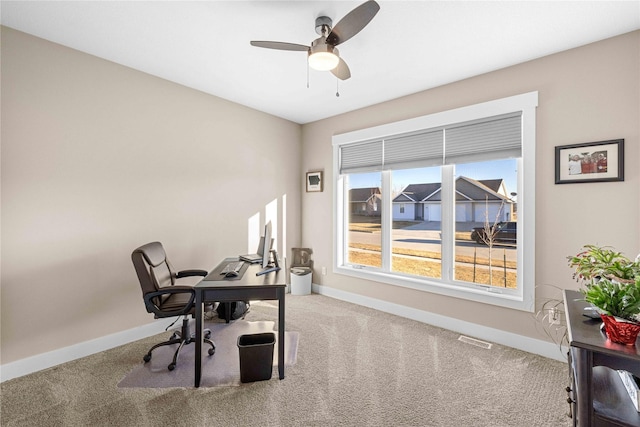 carpeted home office with a ceiling fan, visible vents, and baseboards