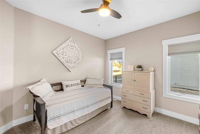 bedroom with baseboards, a ceiling fan, and light colored carpet