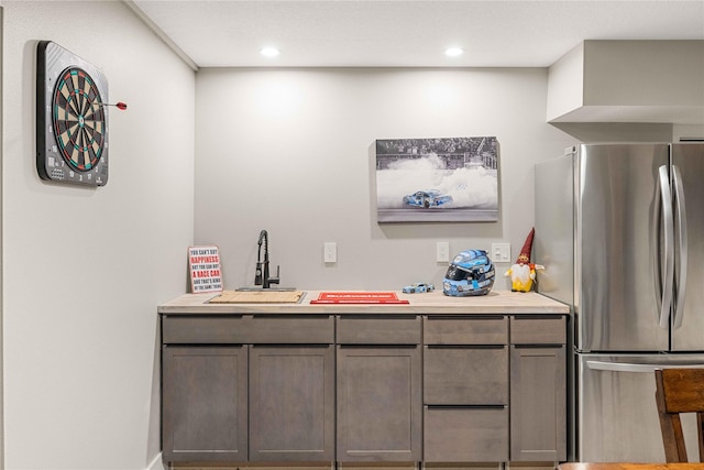 bar with recessed lighting, a sink, and freestanding refrigerator