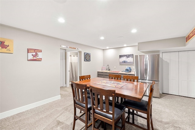 dining area featuring light carpet, baseboards, and recessed lighting