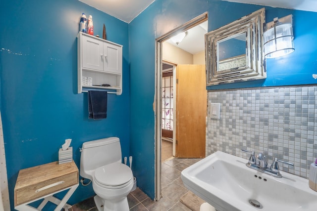 bathroom with a sink, toilet, and tile patterned floors