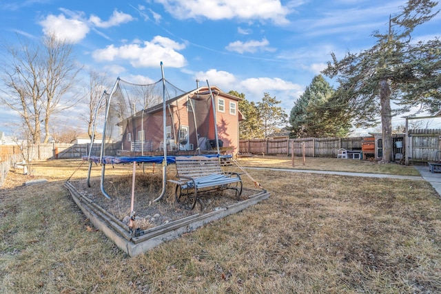 view of yard featuring a trampoline and a fenced backyard