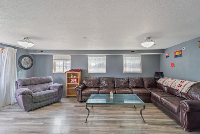 living area with a textured ceiling and wood finished floors