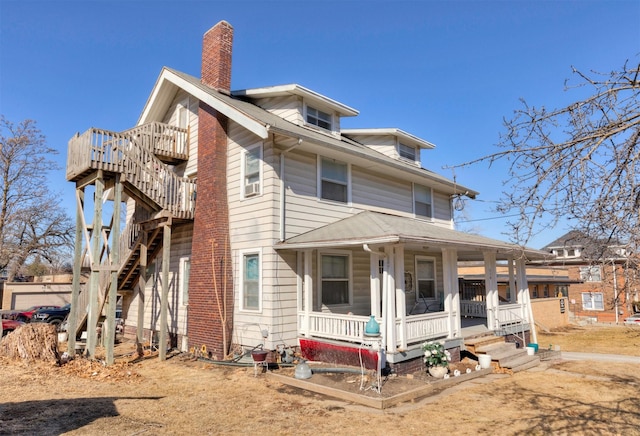 traditional style home featuring covered porch, a chimney, and stairs