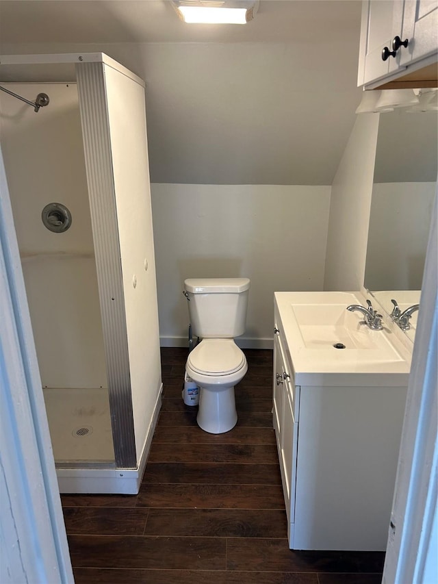 full bathroom featuring a stall shower, lofted ceiling, toilet, wood finished floors, and vanity