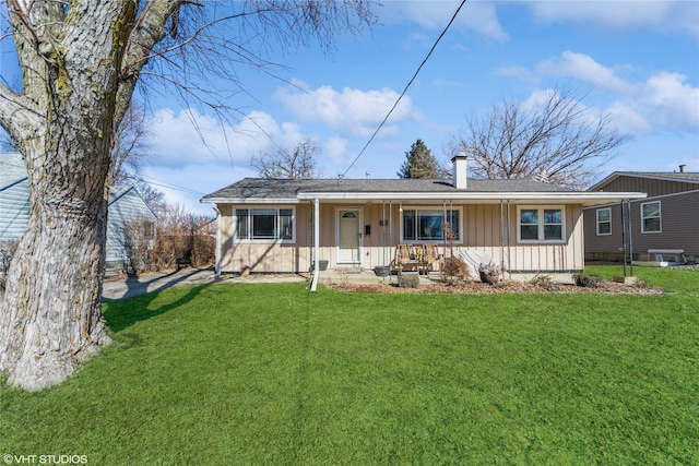 ranch-style house featuring a chimney, a porch, board and batten siding, and a front yard