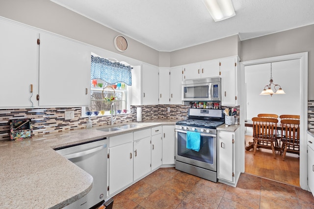 kitchen featuring tasteful backsplash, appliances with stainless steel finishes, light countertops, and a sink