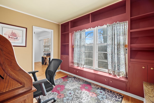 office area featuring crown molding, built in features, wood finished floors, and baseboards