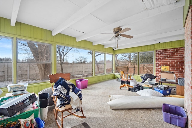 sunroom featuring beam ceiling and a ceiling fan