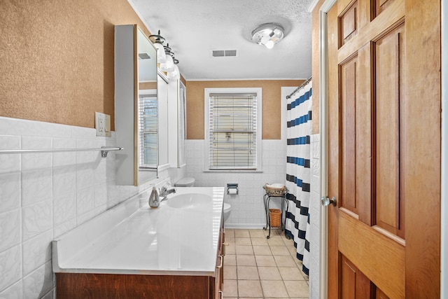 bathroom with visible vents, toilet, vanity, tile patterned floors, and a textured ceiling