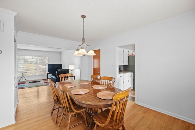 dining area with crown molding, light wood-type flooring, and baseboards