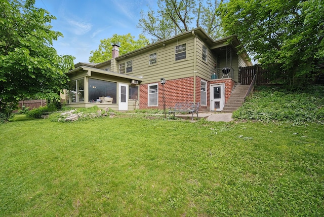 5808 Chamberlain Dr, Des Moines, IA 50312 - back of property with brick siding, a chimney, a sunroom, and stairway