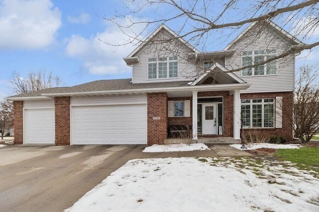 view of front of home featuring a garage, driveway, and brick siding