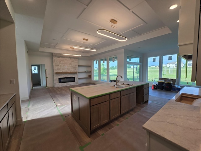4732 162nd St, Urbandale, IA 50323 - kitchen with a sink, open floor plan, a fireplace, a center island with sink, and wood finished floors