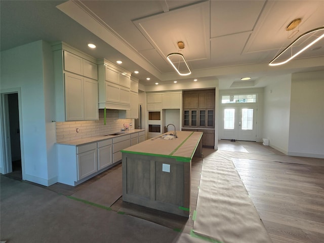 4732 162nd St, Urbandale, IA 50323 - kitchen with a sink, a center island with sink, baseboards, tasteful backsplash, and cooktop