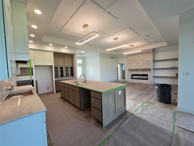 4732 162nd St, Urbandale, IA 50323 - kitchen with a sink, an island with sink, a fireplace, open floor plan, and recessed lighting