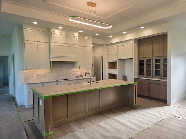 4732 162nd St, Urbandale, IA 50323 - kitchen featuring a kitchen island with sink, tasteful backsplash, white cabinetry, recessed lighting, and light wood finished floors