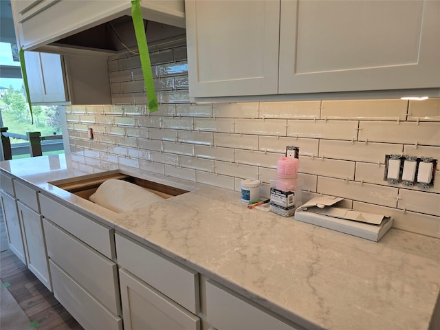 4732 162nd St, Urbandale, IA 50323 - kitchen with backsplash, light stone counters, white cabinets, and dark wood finished floors