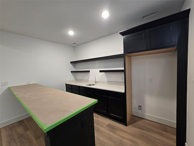 4732 162nd St, Urbandale, IA 50323 - kitchen with open shelves, light wood-type flooring, a peninsula, baseboards, and dark cabinets