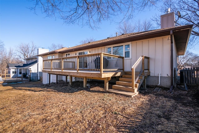 back of house featuring a chimney, fence, board and batten siding, and a wooden deck