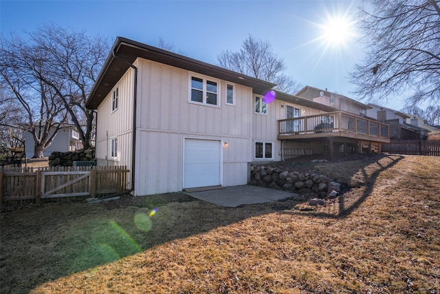 rear view of house featuring a garage and fence