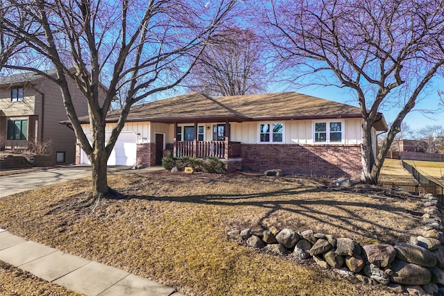 single story home with concrete driveway, brick siding, board and batten siding, and an attached garage