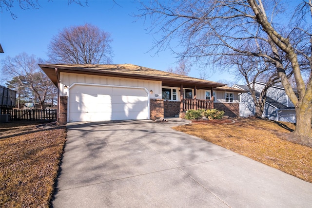 single story home with brick siding, covered porch, board and batten siding, a garage, and driveway