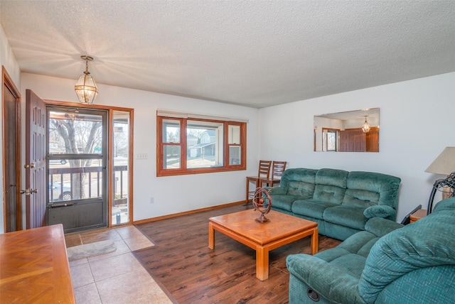 living area with a textured ceiling, wood finished floors, and baseboards