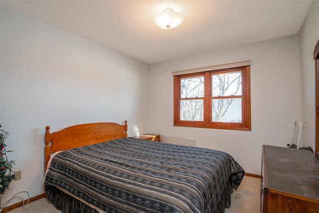 bedroom featuring a textured ceiling, carpet, and baseboards