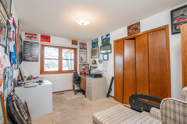 office space featuring a textured ceiling, baseboards, visible vents, and light colored carpet