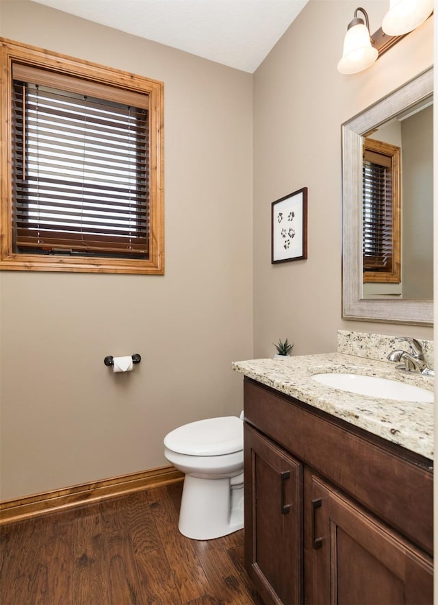 14201 Brookview Dr, Urbandale, IA 50323 - half bathroom with wood finished floors, toilet, vanity, and baseboards