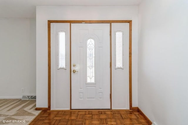 foyer entrance featuring visible vents and baseboards